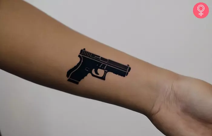 A small glock tattoo on the wrist