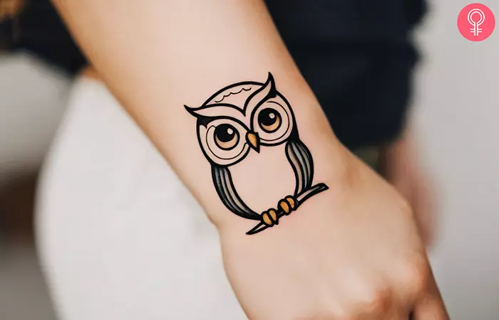 A small owl tattoo on a woman’s wrist