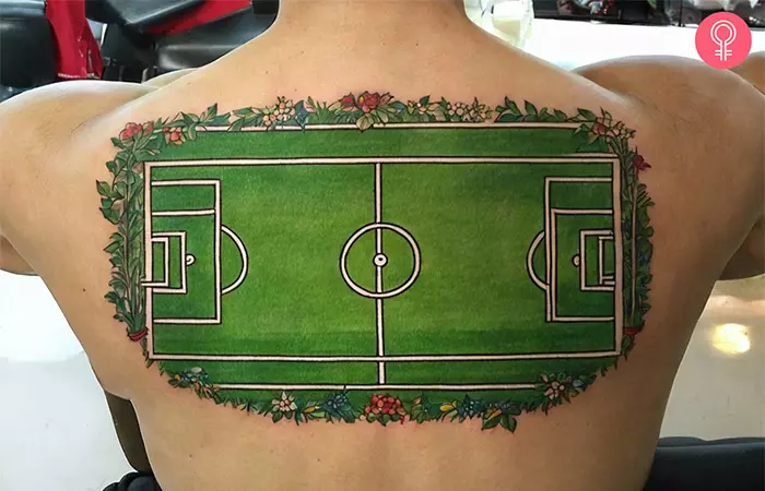 A soccer field tattoo on the back of a man