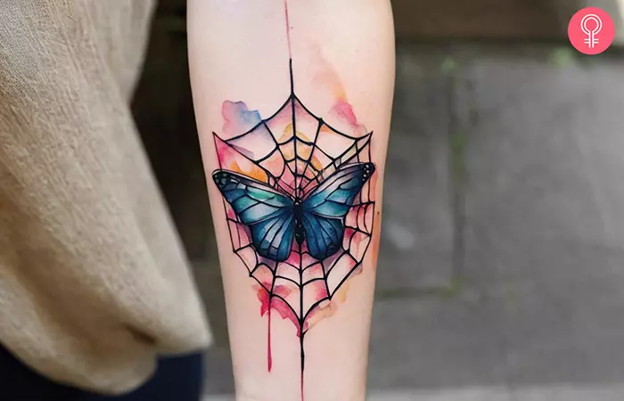 A spider and butterfly tattoo on the forearm