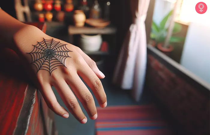 A spider web tattoo design on the hand