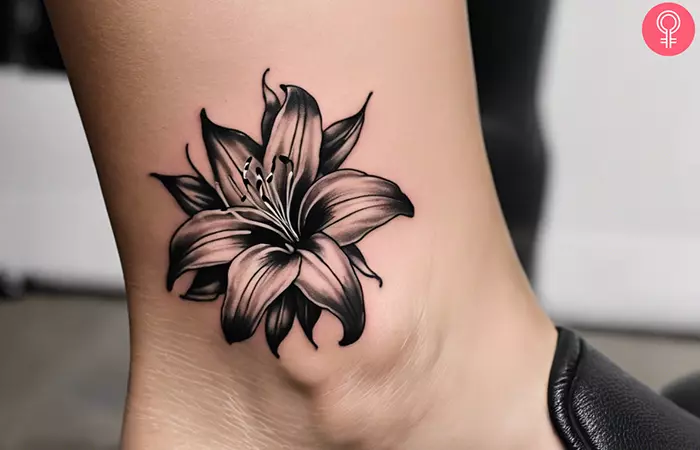 A stargazer black and white lily tattoo on the ankle