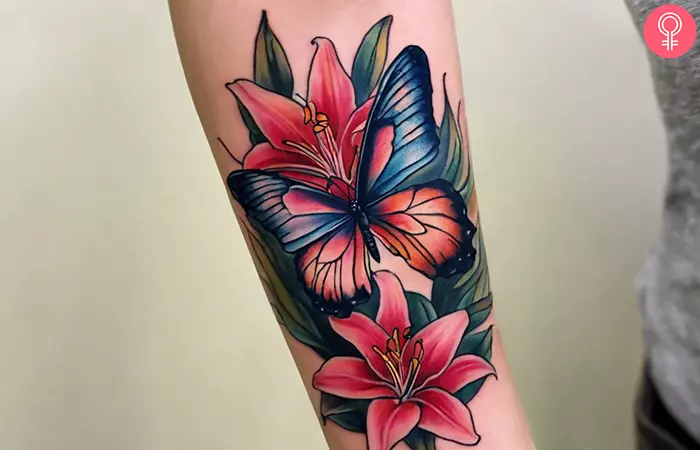A stargazer lily and butterfly tattoo on the forearm