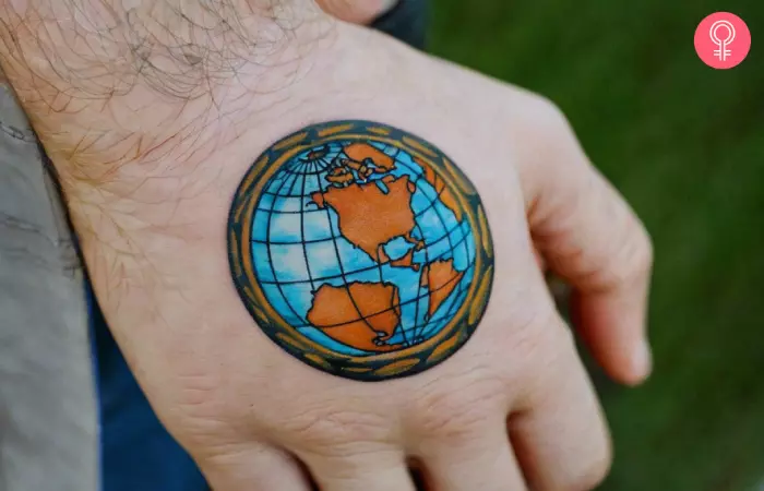 A traditional globe tattoo on the hand of a man