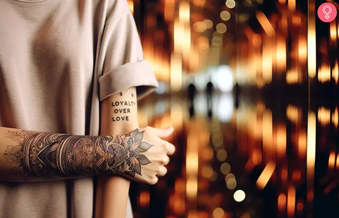 A vertically written loyalty over love tattoo