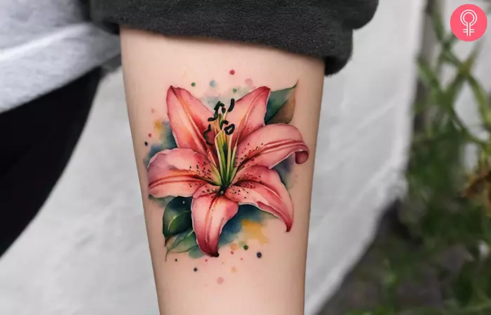 A watercolor stargazer lily tattoo on the forearm