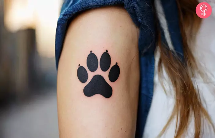 A woman with a Chihuahua paw print tattoo on her upper arm