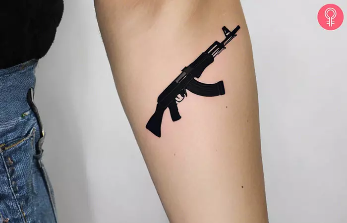 A woman with a black AK-47 Tattoo