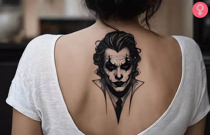 A woman with a black Joker face tattoo on the back