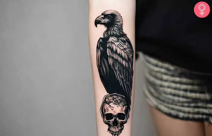 A woman with a black-and-gray vulture skull tattoo on her forearm