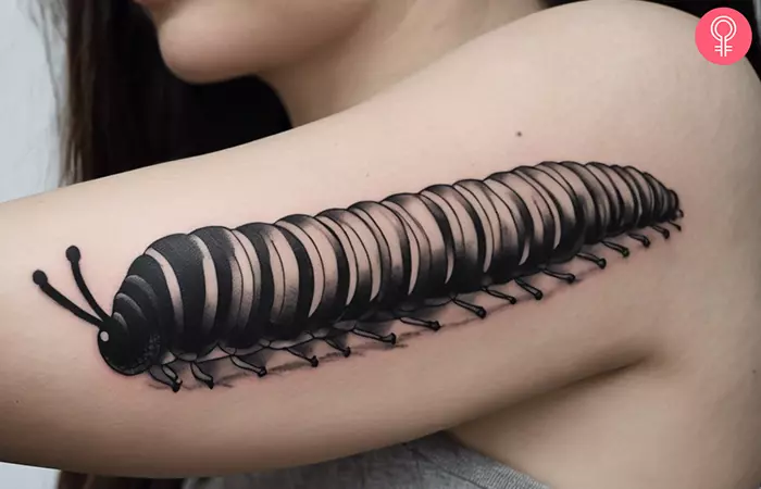 A woman with a black and white caterpillar tattoo on her arm