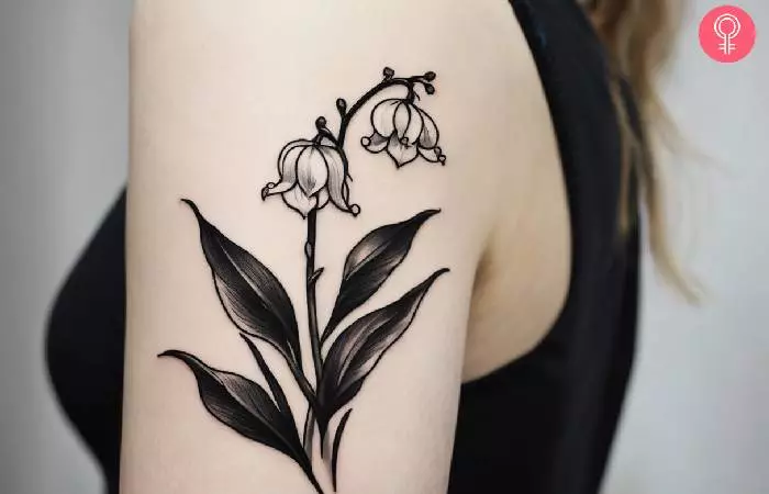 A woman with a black and white lily of the valley tattoo