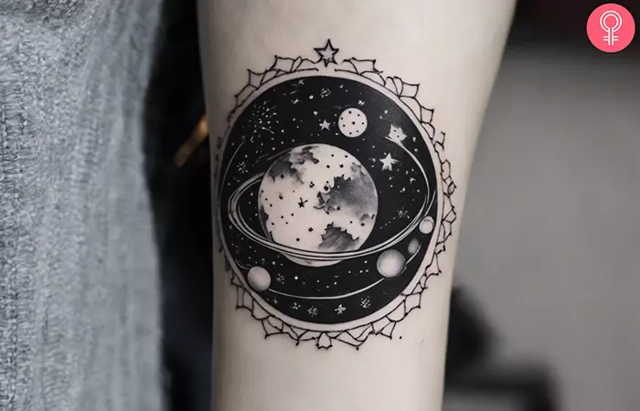 A woman with a black and white night sky universe tattoo on her wrist