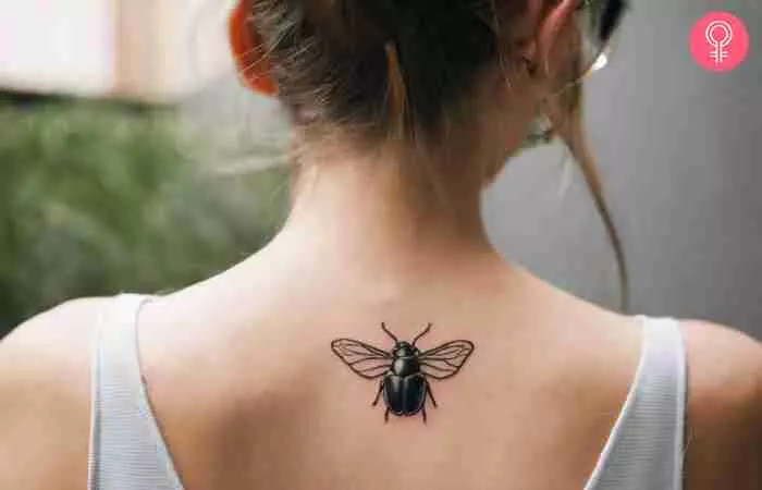 A woman with a black beetle tattoo on her back