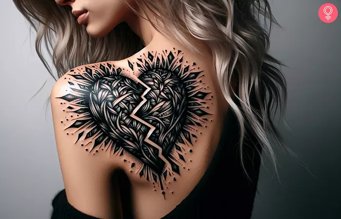 A woman with a black broken heart tattoo on her left shoulder blade