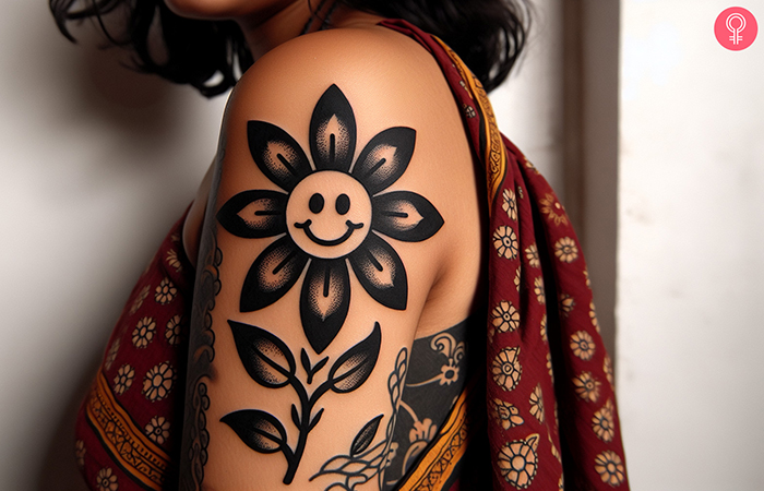 A woman with a black cartoon flower tattoo on her upper arm
