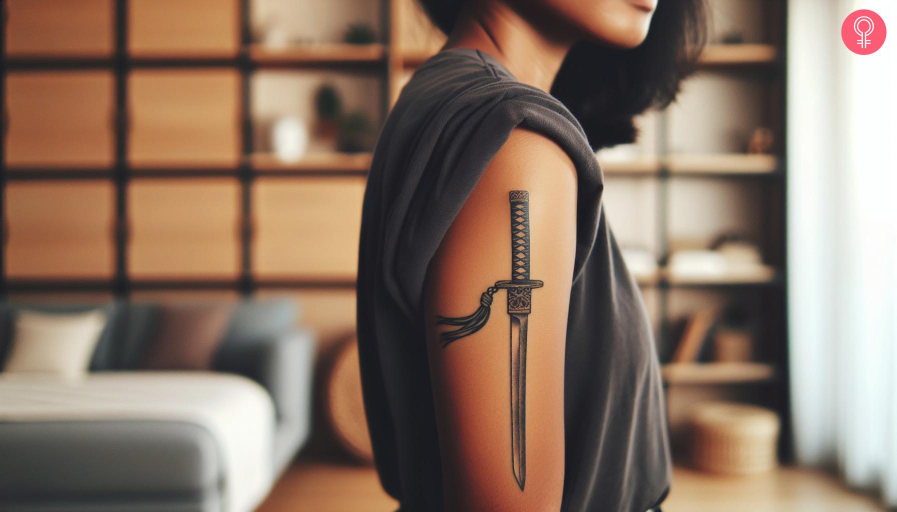 A woman with a black katana sword tattoo on her upper arm