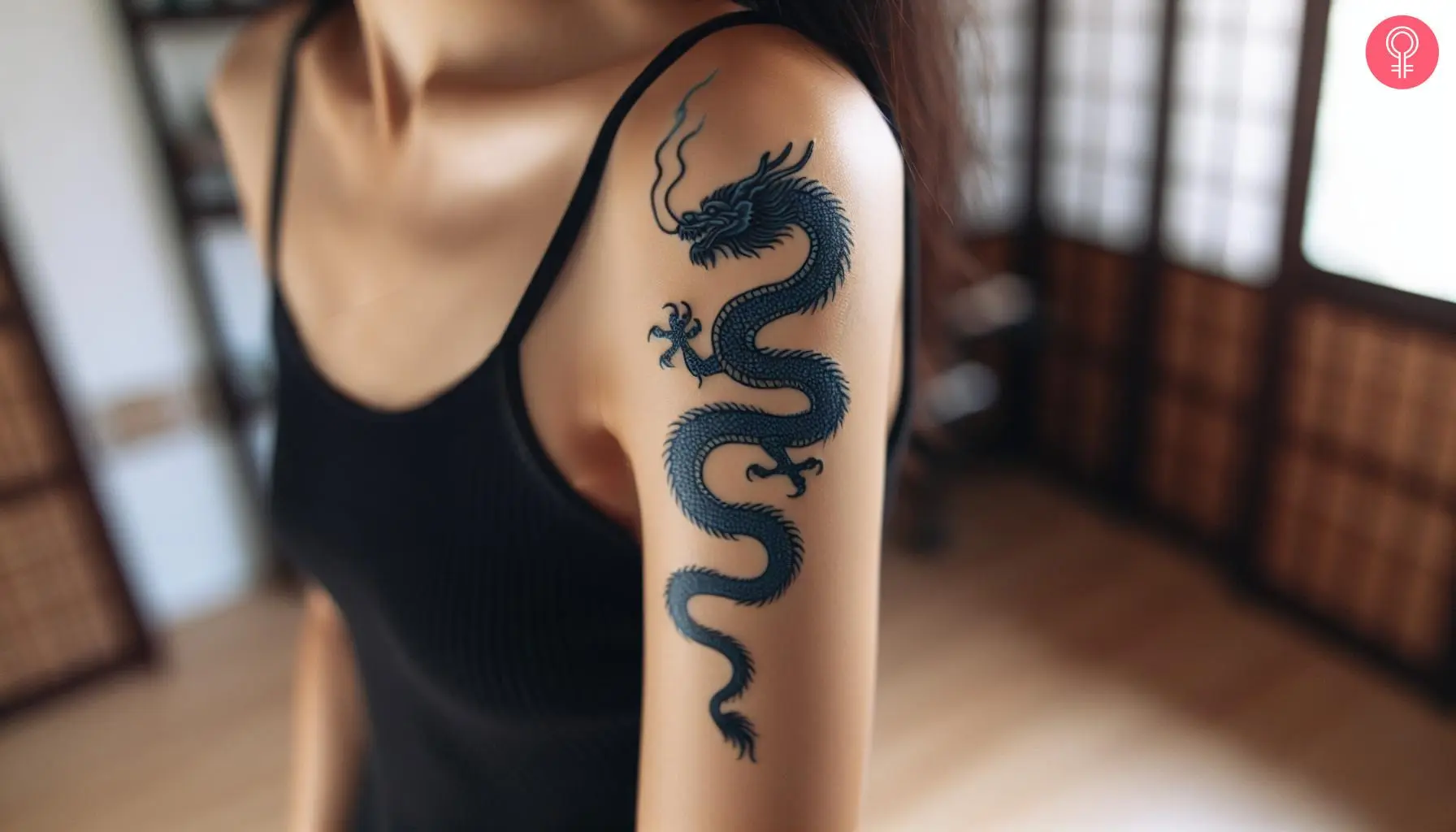 A woman with a blue-inked Japanese dragon tattoo on her upper arm