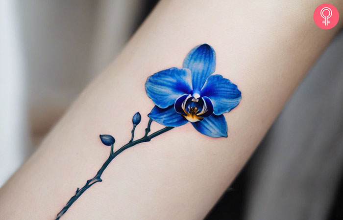 A woman with a blue orchid tattoo on her arm