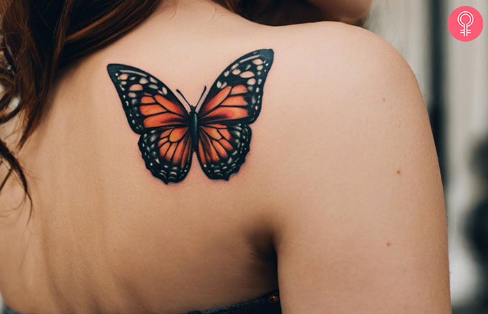 A woman with a butterfly tattoo design on her upper back