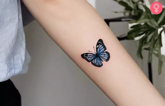 A woman with a butterfly tattoo on her forearm