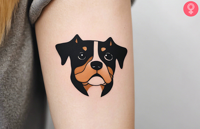 A woman with a cartoon dog tattoo on her upper forearm
