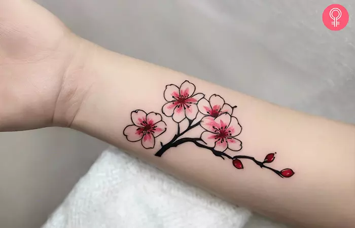 A woman with a cherry blossom tattoo on her wrist