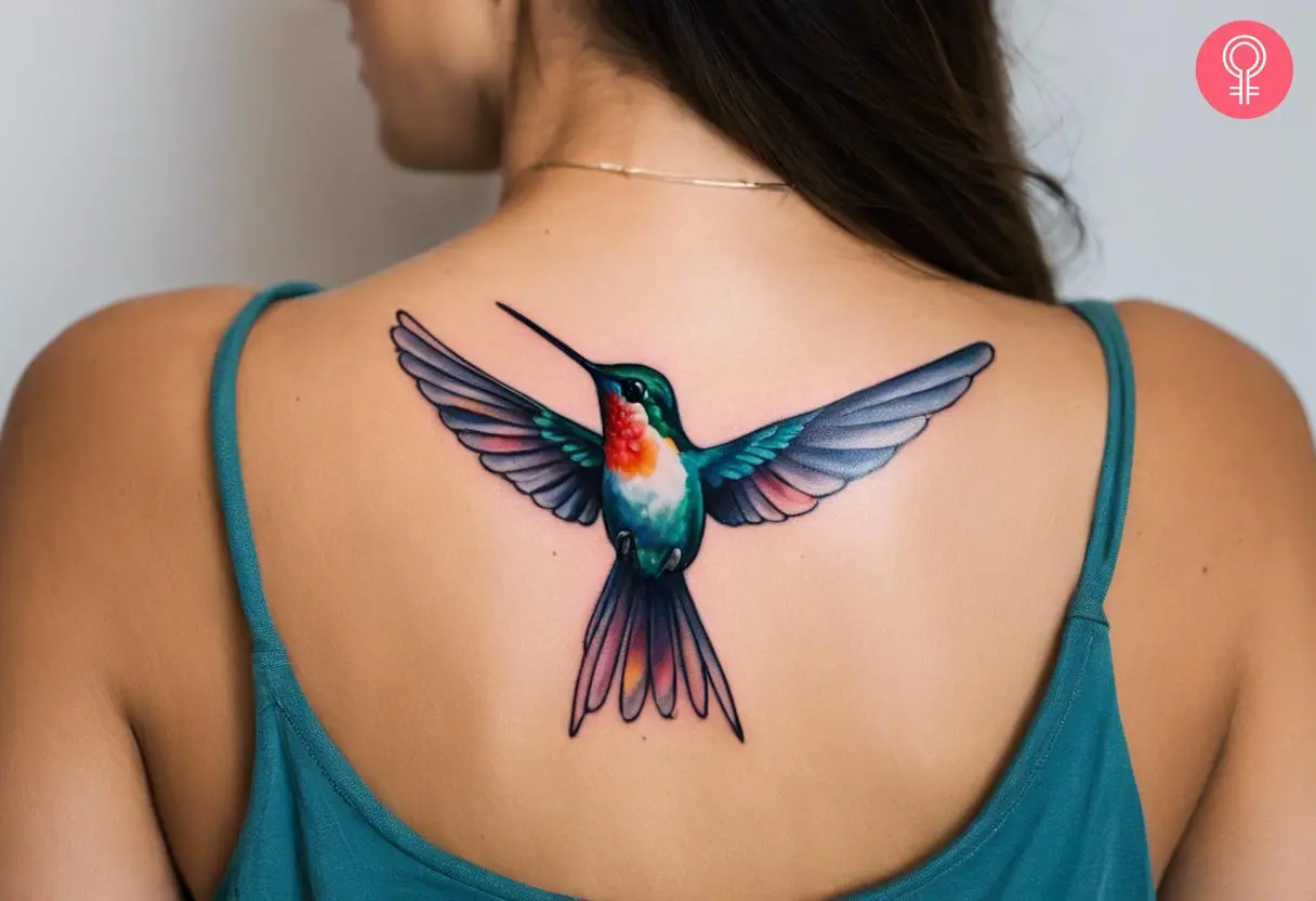 A woman with a colorful hummingbird tattoo on her upper back