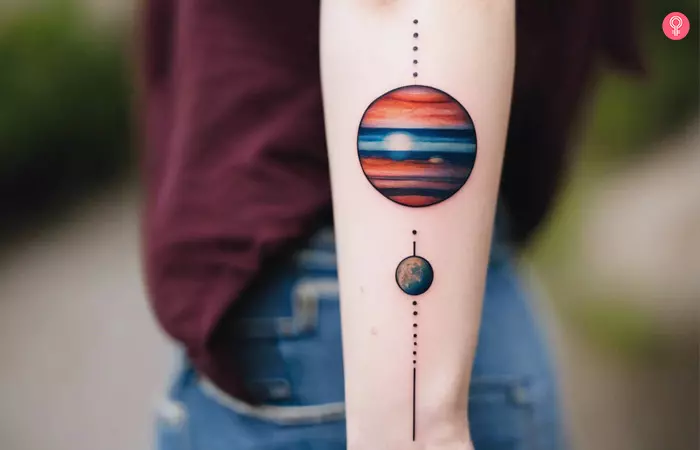 A woman with a colorful jupiter planet tattoo on her forearm