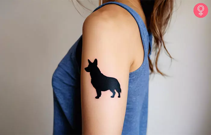 A woman with a corgi silhouette tattoo on her upper arm
