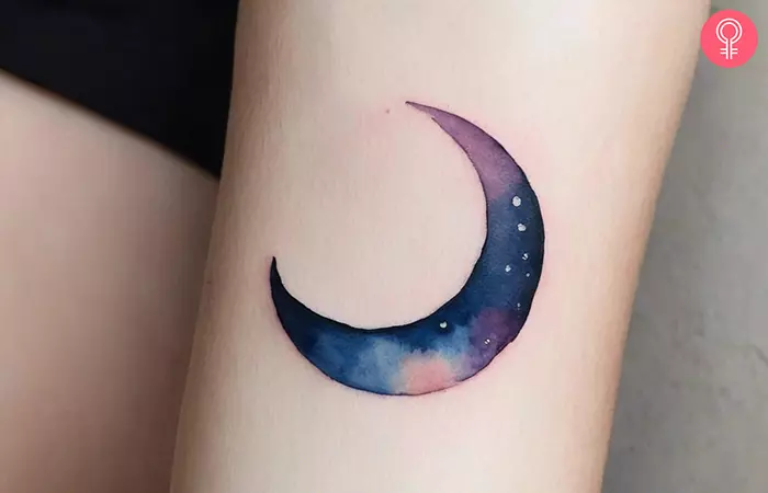 A woman with a crescent moon tattoo on her forearm