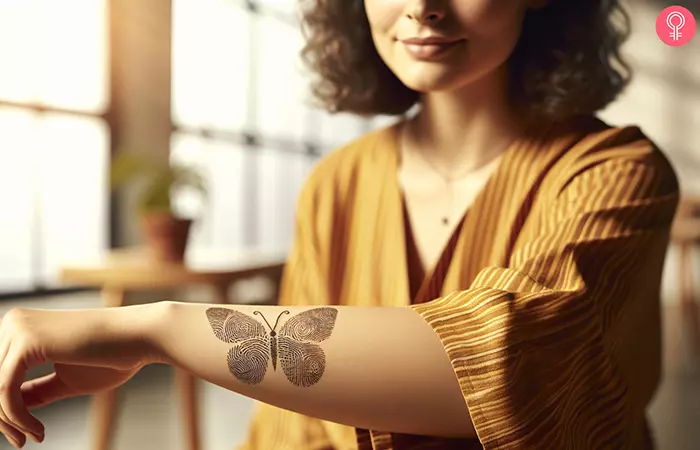 A woman with a fingerprint butterfly tattoo on her forearm