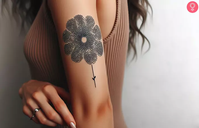 A woman with a fingerprint flower tattoo on her upper arm