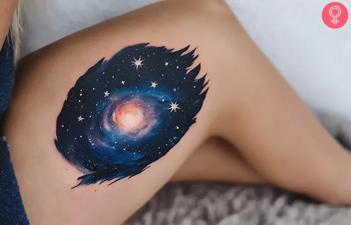 A woman with a galaxy night sky tattoo on her thigh