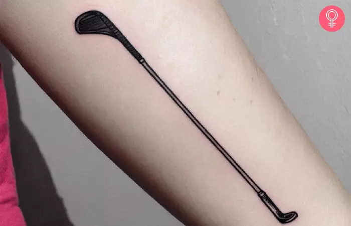 A woman with a golf club tattoo on her arm