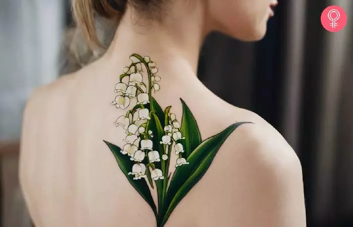 A woman with a lily of the valley tattoo on the shoulder