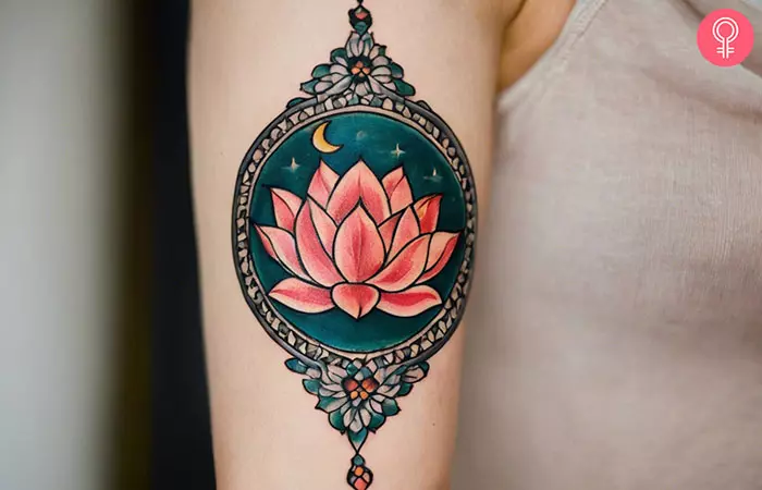 A woman with a lotus and moon tattoo on her upper arm
