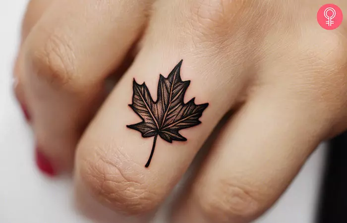 A woman with a maple leaf tattoo on her knuckle