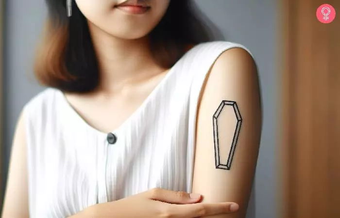 A woman with a minimalist coffin tattoo