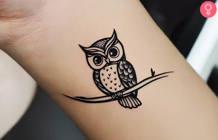 A woman with a minimalist owl tattoo on her wrist