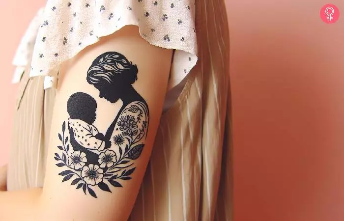 A woman with a mom and baby tattoo on her upper arm