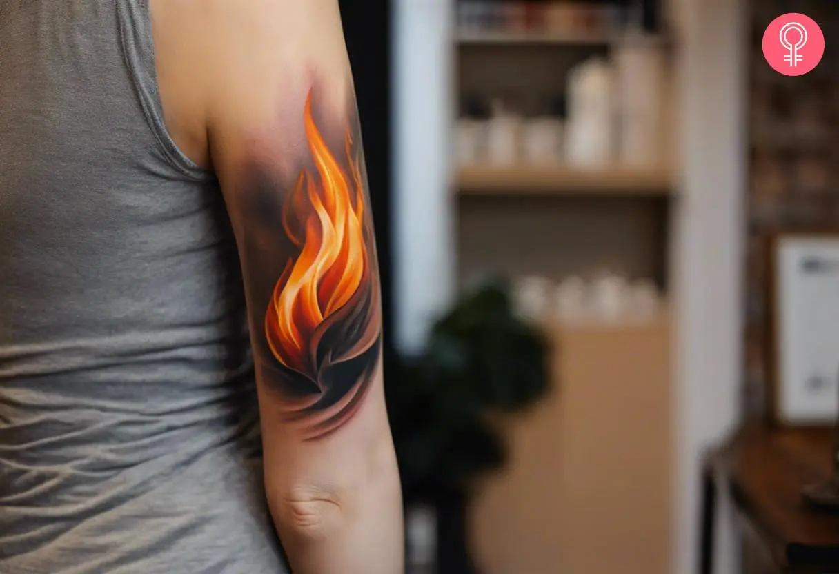 A woman with a realistic flame tattoo on her upper arm