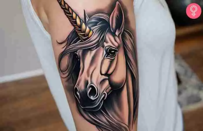 A woman with a realistic unicorn tattoo on her upper arm