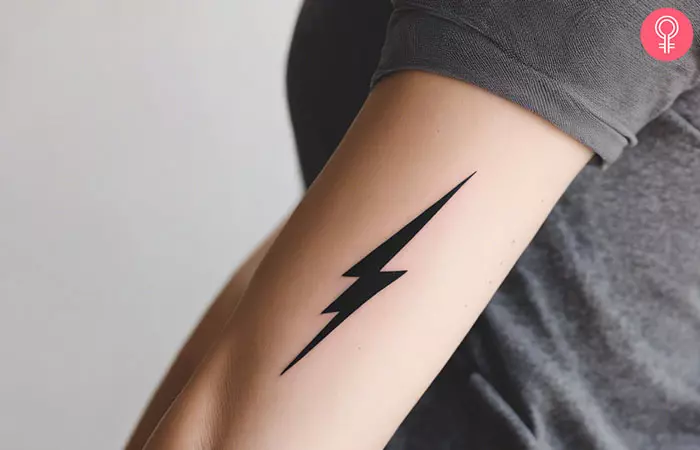 A woman with a simple lightning bolt tattoo on her upper arm