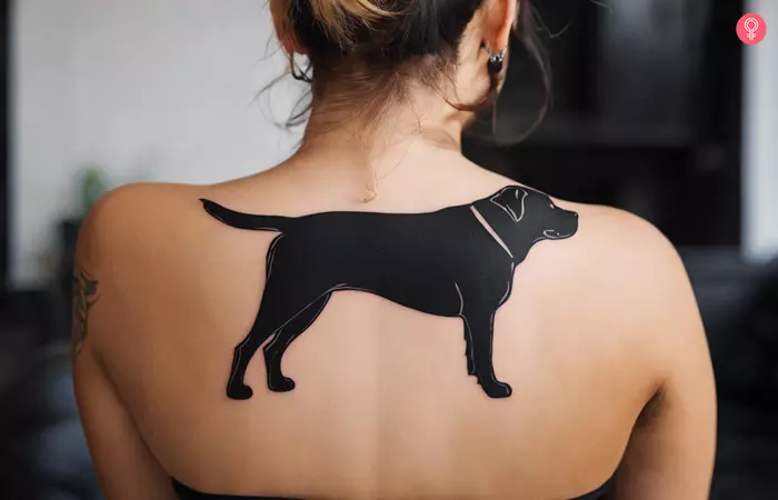 A woman with a simple rottweiler tattoo on her ankle