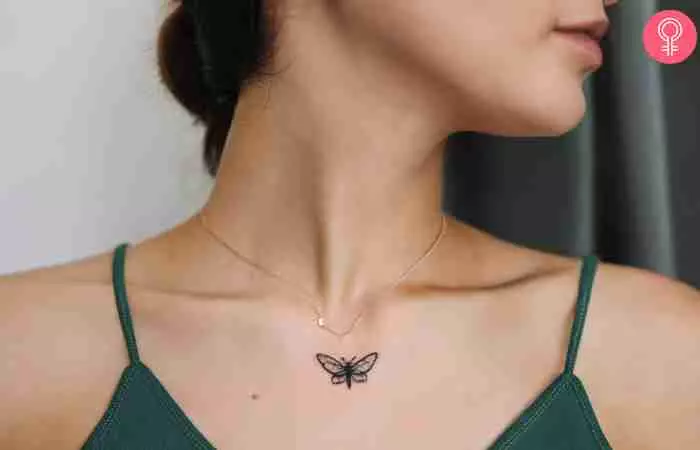 A woman with a small butterfly tattoo on her neckline