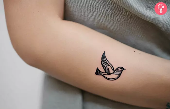 A woman with a small dove tattoo on her arm