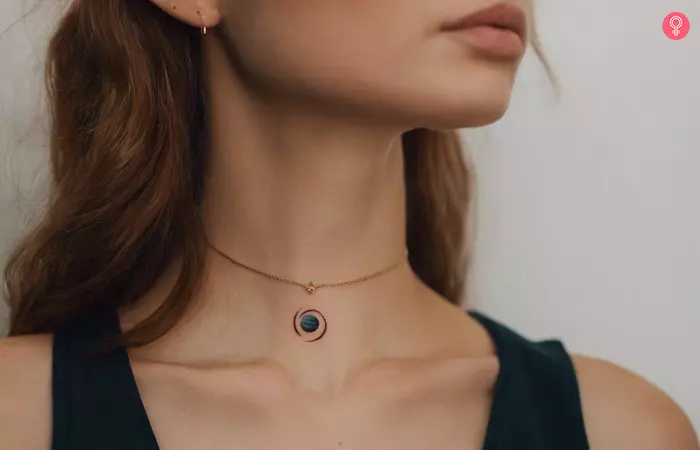 A woman with a small jupiter planet tattoo on her neck