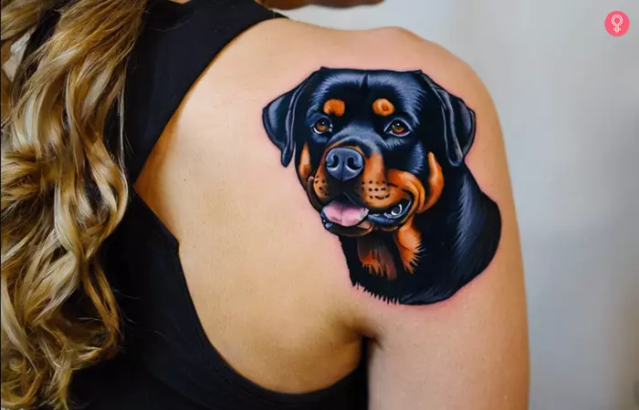 A woman with a traditional rottweiler tattoo on her upper shoulder