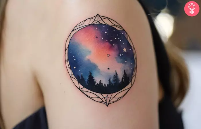 A woman with a watercolor night sky tattoo on her shoulder